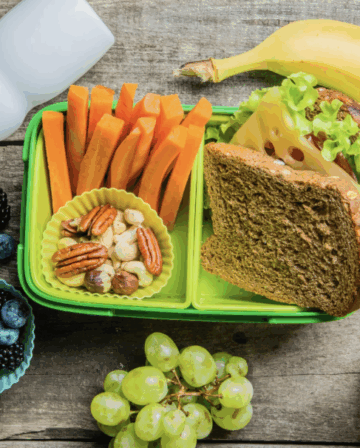 lunchbox with bread, veggies, fruits, and milk