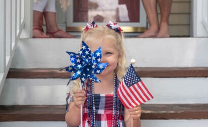 portrait smiling girl holding american flag steps