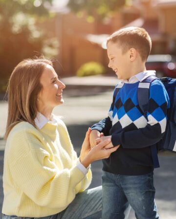 mother kid first school day side view