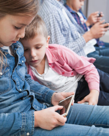 boy looking sister using smartphone