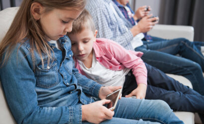 boy looking sister using smartphone